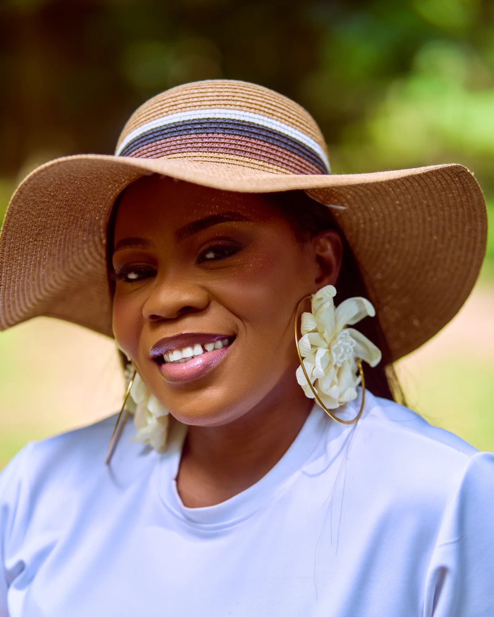 Ebahi smiling in a wide-brimmed hat