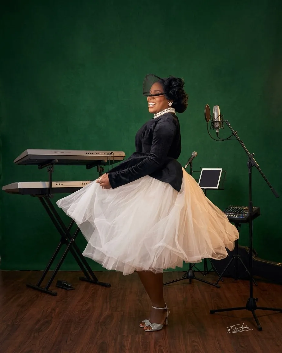 Ebahi in the studio, keyboards and a microphone behind her