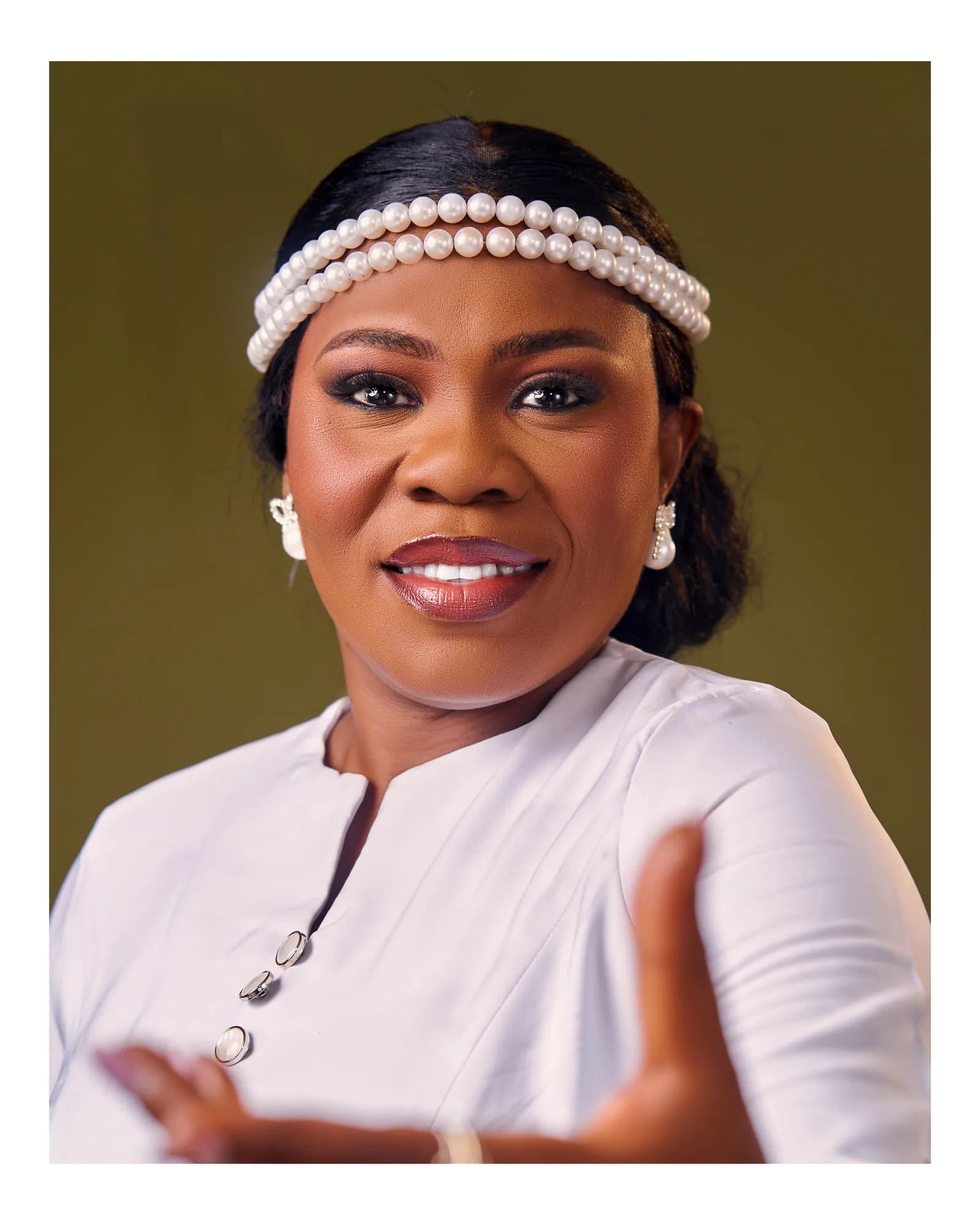 Ebahi Tayo-Ogunleye smiling, hands open