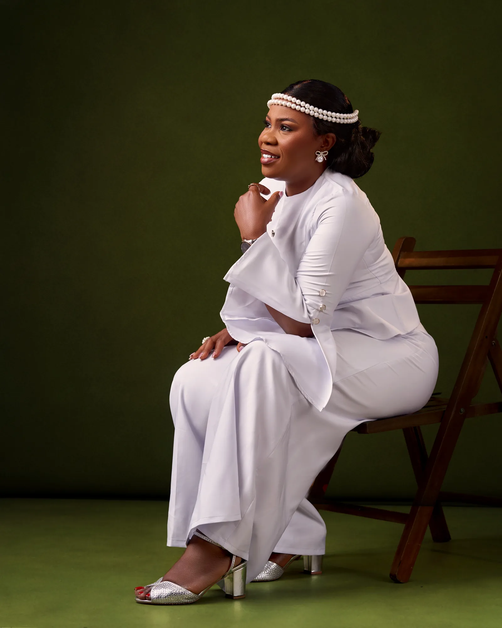 Ebahi seated in white, in profile