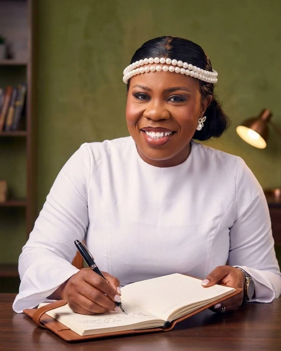 Ebahi writing in a journal at her desk